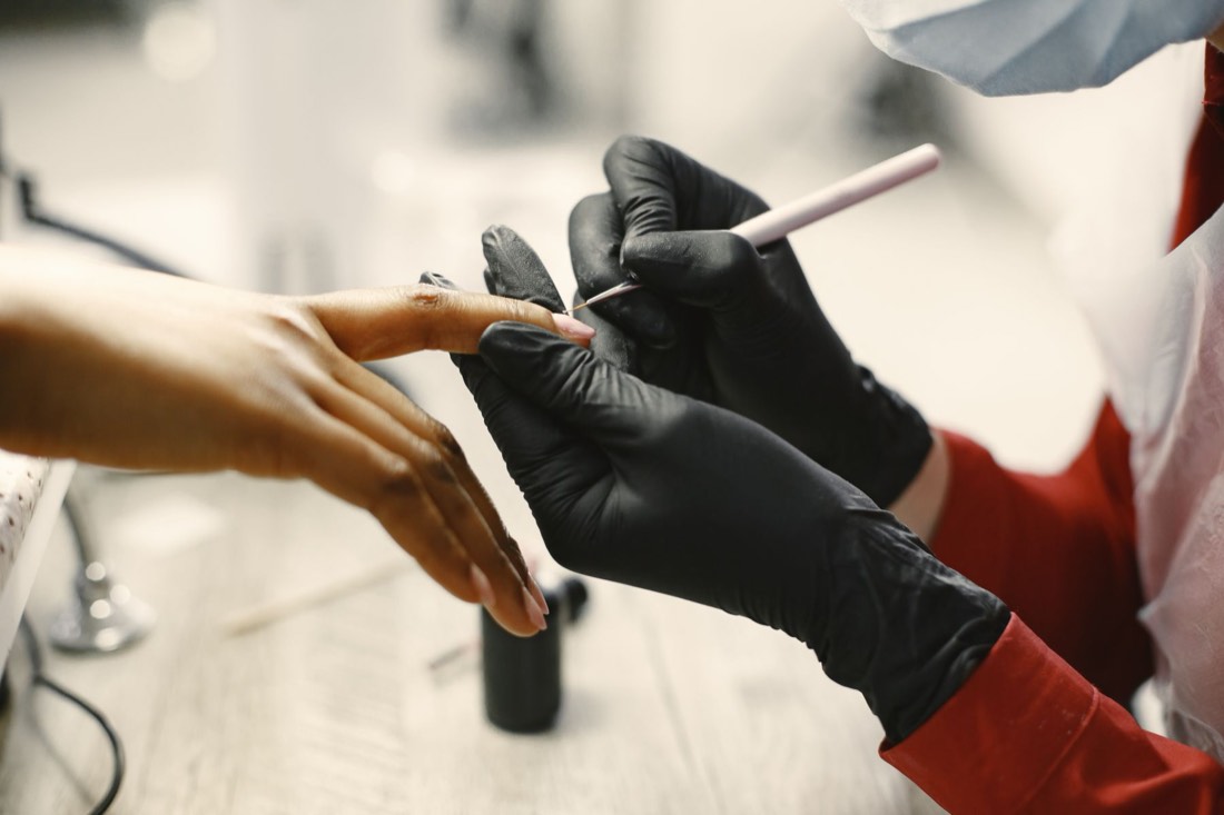 A manicurist working on a client's nails